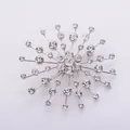 Detailed macro view of a sparkling snowflake brooch featuring clear crystal rhinestones - Silver