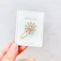 Nahaufnahme einer funkelnden Strass-Schneeflocken-Brosche auf einer weißen Schmuckkarte. - Schneeflocke Strass 09