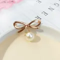 Elegante spilla a fiocco dorato con perla bianca pendente per abbigliamento da donna. - Fiocco Lucido / Oro Angelo (A6-18)