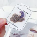 Elegant cloud and moon brooch featuring purple and gold rhinestones on white display card - Purple Moon Style (LY1)