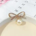 Elegante spilla a fiocco dorata con strass scintillanti e perla pendente di classe - Fiocco in Strass / Strass Oro (A6-20)