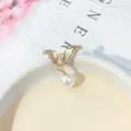 Elegante spilla a fiocco dorata con strass scintillanti e una perla bianca pendente - Forma di Ala con Strass / Oro Alato (A6-22)