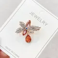 Elegant orange flower brooch pin with teardrop crystal pendant on white jewelry card - Orange Flower Rhinestone Style (A10-66)