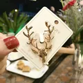 Eleganter goldener Hirschkopf-Anstecknadel-Schmuck auf einer Karte im Café-Ambiente - Goldener Hirschkopf (A5-3)