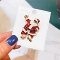 Festliche rote Glitzer-Emaille-Weihnachtsmann-Brosche auf einer weißen Displaykarte - Tanzender Weihnachtsmann (A5-64)