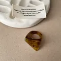 Detailed macro view of a faceted amber resin ring featuring a unique marble swirl texture. - Faceted Smudge Ring / Dark Coffee