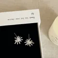 Detailed view of silver firework starburst stud earrings featuring clear center zircon stones - Style 29 Earrings