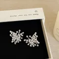 Close-up of exquisite zircon and pearl fireworks stud earrings in a white gift box - Style 30 Earrings