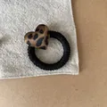 Detailed close-up of a vintage leopard print heart hair tie on textured grey fabric - Heart Hair Tie (2#) / Leopard Print