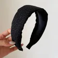 Detailed close-up view of a black padded headband featuring white polka dot patterns. - Black Polka Dot Headband