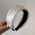 Detail showing the elegant cream satin texture of a French style wide padded headband - White