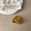 Gros plan d'une bague irrégulière en résine ambrée avec motif marbré unique - Bague Café Clair