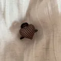Close-up detail of a brown polka dot heart-shaped hair claw clip on soft beige linen fabric - Hair Claw / Coffee
