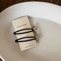 Detail van minimalistische matzilveren metalen haarspeldjes op een witte kaart - Strik Stijl (2#) / Eén Paar / Zilver
