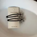 Detail van matzwarte en zilveren bloemen haarspelden op een displaykaart. - Grote Bloemen Stijl (1#) / Eén Paar / Zilver