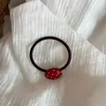 Detalle de un coletero rojo con lunares blancos y colgante ovalado minimalista. - Rojo