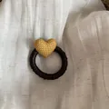 Close-up detail of a dark satin hair tie with a mustard yellow polka dot heart ornament. - Hair Tie / Yellow