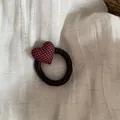 Detail view of a burgundy polka dot heart hair tie on cream linen background - Hair Tie / Red