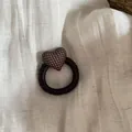 Detailed view of a dark brown elastic hair scrunchie with a brown polka dot padded heart charm. - Hair Tie / Coffee