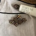 Detail view of leopard print and brown fabric star hair clips on a linen background - Star Hair Clip / 1PCS / Coffee Patchwork