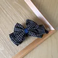 Macro view of vintage brown gingham checkered bow hair clip on a wooden surface - Blue Plaid Bow Banana Clip