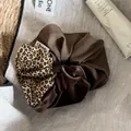 Detail showing patchwork leopard print, brown fabric, and velvet scrunchie texture. - Scrunchie / Coffee Patchwork