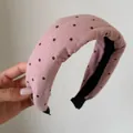 Dettaglio ravvicinato della trama di un cerchietto imbottito rosa a pois neri retrò - Pois Rosa