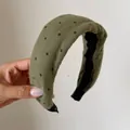 Primo piano di una fascia vintage a pois verdi con un design morbido a tesa larga - Pois Verdi