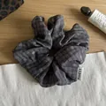 Detailed view of a dark grey plaid scrunchie with subtle star patterns on wood surface - Gray Stripes and Stars
