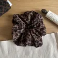 Leopard print scrunchie hair tie with brown tones shown in a lifestyle setting - Coffee and Black Leopard