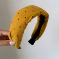 Primo piano di cerchietto imbottito giallo retrò a pois in morbido tessuto con imbottitura - Pois Gialli