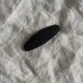 Detailansicht einer schwarzen Haarklammer mit weißen Punkten auf Leinen. - Wassertropfen-Form Haarklammer / Schwarz