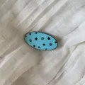Close-up of light blue acetate hair clip with black star pattern on linen background - 7# Blue Oval Clip
