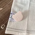 Nahaufnahme einer rosa matten Bären-Haarklammer mit Textdetail auf einem weißen Tuch. - 2.5cm / Hellrosa Bär Haarklammer