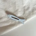 Primer plano de una pinza para el pelo con forma de pez azul y ojo de diamante. - Azul Liso