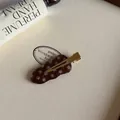 Detalle de una pinza para el pelo de acetato marrón con lunares blancos y clip dorado. - Pinza de Pico de Pato Ondulada / Pinza de Pelo Ondulada Café