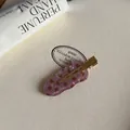 Detalle de pinza para el cabello en acetato con lunares rosa-marrón sobre fondo de cuero blanco. - Pinza de Pico de Pato Ondulada / Pinza de Pelo Ondulada Rosa