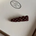 Detailopname van een bruine gegolfde acetaat haarklem met wit polkadot patroon - Koffie Driehoek Golf Haarspeld
