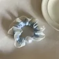 Detail van een lichtblauwe en witte geplooide scrunchie met een grote decoratieve parel - Witte Kant Blauw Haarelastiekje met Parel