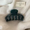 Detailed view of large forest green glossy hair claw clip for elegant styling - Transparent Green