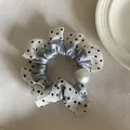 Detail shot of a polka dot scrunchie with grey satin inner and a large white pearl. - Black Polka Dot White Edge Blue Hair Tie