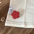 Close-up detail of a red flower-shaped hair clip placed on a white fabric background - 2.5cm / Red Floral Hair Pin