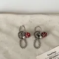 Gedetailleerde weergave van vintage oorbellen met knoopbedels en polkadot kralen - Oorbellen