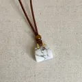 Detail van een wit marmeren handtas hanger aan een bruine koord ketting voor dames - Witte Turkoois Tas Ketting