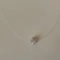 Close-up detail of a minimalist transparent fish line necklace with crystal ball pendant. - Sparkling Laser Ball Necklace