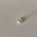 Close-up detail of a minimalist white pearl pendant on an invisible fishing line cord. - Small Artificial Pearl Necklace