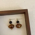 Close-up detail of vintage Maillard brown resin stud earrings with black bead accents - Style 1 (925 Silver Post)