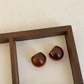 Detailed macro view of translucent coffee brown resin stud earrings on a textured canvas background - Style 6 (925 Silver Post)