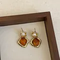 Detailed view of vintage amber resin earrings with pearl accents in gold frame. - Style 10 (925 Silver Post)