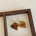 Close-up of elegant amber resin heart earrings with gold metallic texture - Style 12 (925 Silver Post)